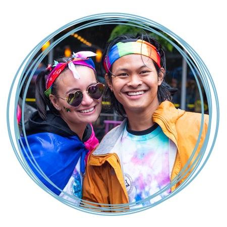 在波特兰骄傲游行中，两名英国东北大学的学生戴着彩虹发带，面带微笑